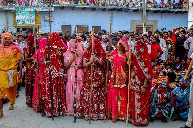 Festivals- Lathmaar Holi of Barsana (India) - women's wearing colorfull saree's holding bamboo sticks during Lathmaar Holi at Barsana, Mathura, Uttar Pradesh, India. by Anil
