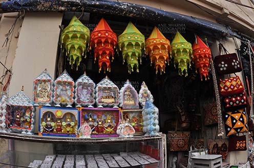Festivals- Jagannath Rath Yatra (Odisha) - Mementos of Lord Jagannath, Balbhadra and Subhadra, handicrafts and chandeliers , on display at the shop near Lord Jagannath Temple at Puri, Odisha, India. by Anil