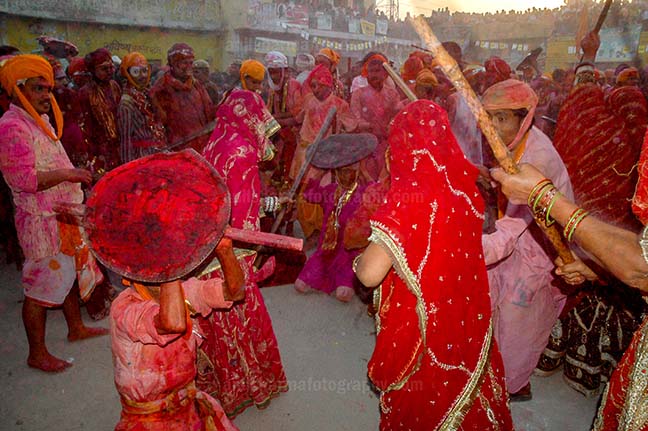 Festivals- Lathmaar Holi of Barsana (India) - A man from Nandgaon protecting himself from womens of Barsana hitting on his shield with their sticks during Lathmaar Holi at Barsana. by Anil