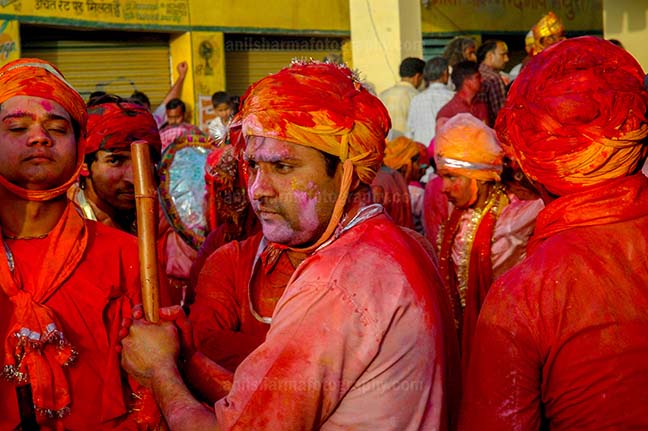 Festivals- Lathmaar Holi of Barsana (India) - A man daubed in color powder holding bamboo stick during lathmaar Holi at Barsana, Mathura, Uttar Pradesh, India. by Anil