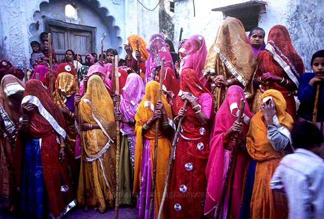Festivals- Lathmaar Holi of Barsana (India) - women's wearing colorful saree's holding bamboo sticks during Lathmaar Holi at Barsana, Mathura, Uttar Pradesh, India. by Anil