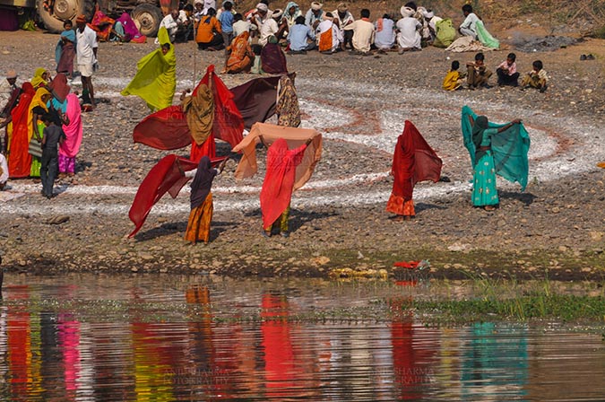 Fairs- Baneshwar Tribal Fair - Baneshwar, Dungarpur, Rajasthan, India- February 14, 2011: Bhil women drying their saris after taking ritual bath at Baneshwar, Dungarpur, Rajasthan, India by Anil