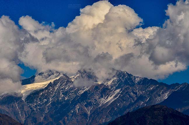 Clouds- Sky with Clouds (Panchchuli Peaks) - Panchchuli Peaks, Munsiyari, Uttarakhand, India- November 2, 2016: Blue sky with bright white clouds over the snow covered Punchchuli Peaks view from Munsiyari, Uttarakhand, India. by Anil