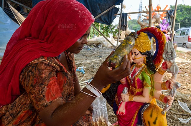 Festivals- Durga Puja Festival - Durga Puja Festival, Noida, Uttar Pradesh, India- September 20, 2017: A Rajasthan tribal artist giving final touches to the Goddess Durga’s clay idol at Noida, Uttar Pradesh, India. by Anil