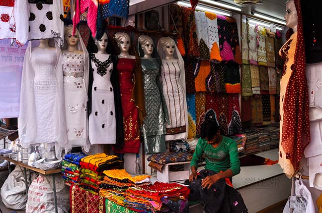Religion- Dargah Sharif, Ajmer, Rajasthan (India) - Ladies suits being sold at shrine market place of Ajmer Sharif Dargah the Mausoleum of Moinuddin Chishti, a sufi saint from India at Ajmer, Rajasthan, India. by Anil