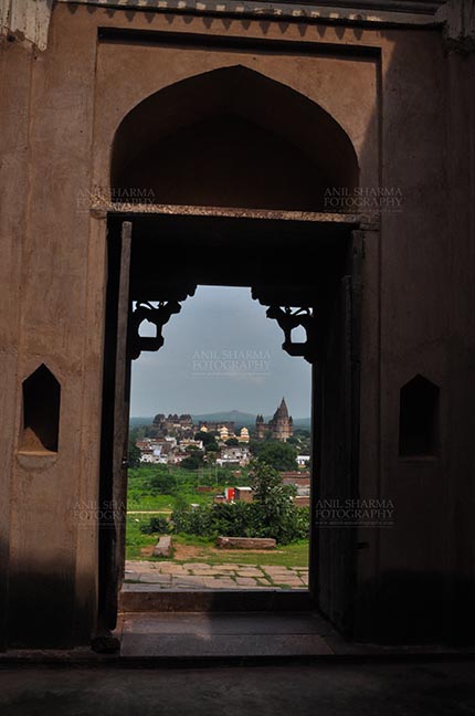 Monuments- Palaces and Temples of Orchha - Orchha, Madhya Pradesh, India- August 20, 2012: View from a carved window of Laxmi Temple, Chaturbhuj temple is seen in the distance, Orchha, Madhya Pradesh, India. by Anil