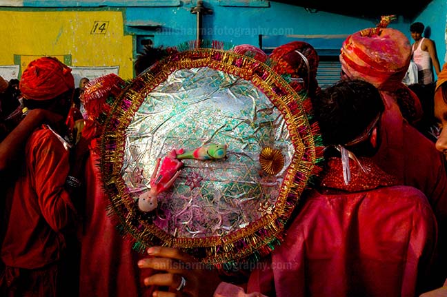 Festivals- Lathmaar Holi of Barsana (India) - A man daubed in color powder holding shield during Lathmaar Holi celebration at Barsana, Mathura Uttar Pradesh, India. by Anil