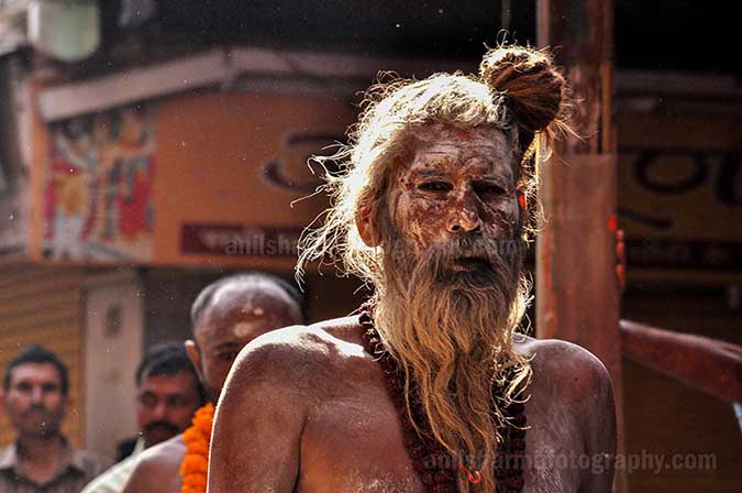 Culture- Naga Sadhu\u2019s (India) - An old Naga Sadhu wearing Rudraksha beads mala passing through a small lane of Varanasi. by Anil
