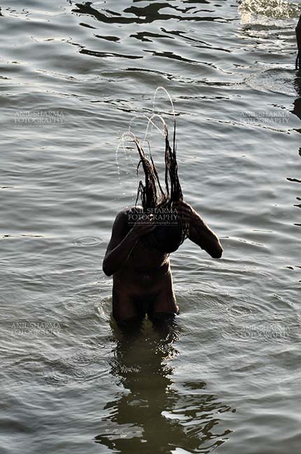 Travel- Varanasi the city of light (India) - A Naga Sadhu taking ritual bath in Ganges River at Varanasi, Uttar Pradesh, India. by Anil
