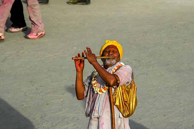 Festivals- Lathmaar Holi of Barsana (India) - An old men playing flute at Barsana, Mathura, India. by Anil