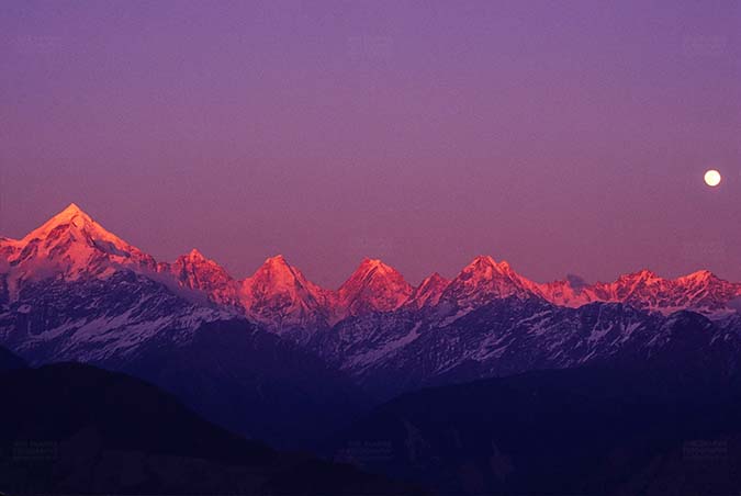 Mountains- Panchchuli Peaks (India) - Pink color Panchchuli Peaks and full moon in the sky view from Munsyari at Uttarakhand, India. by Anil