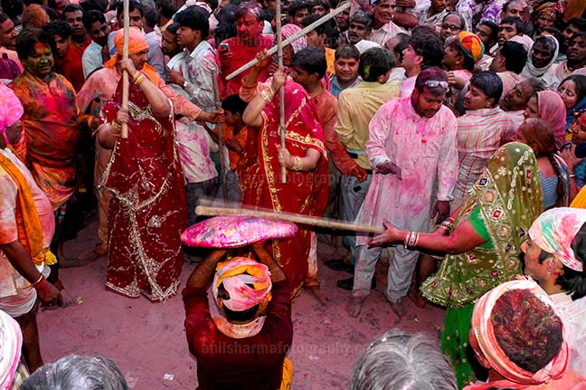 Festivals- Lathmaar Holi of Barsana (India) - A man protecting himself from womens of Barsana hitting on his shield with their sticks during Lathmaar Holi at Barsana. by Anil