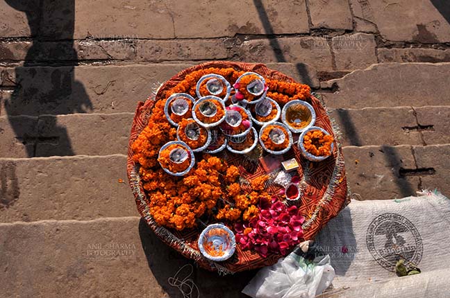 Travel- Varanasi the city of light (India) - Hindu devotees use marigold and rose flowers, cotton, ghee, sweets and red powder in puja. by Anil