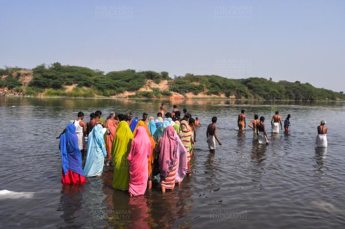 Fairs- Baneshwar Tribal Fair - Baneshwar, Dungarpur, Rajasthan, India- February 14, 2011: Devotees ready for the traditional ritual bath at the confluence of the rivers, Mahi and Som at Baneshwar, Dungarpur, Rajasthan, India by Anil