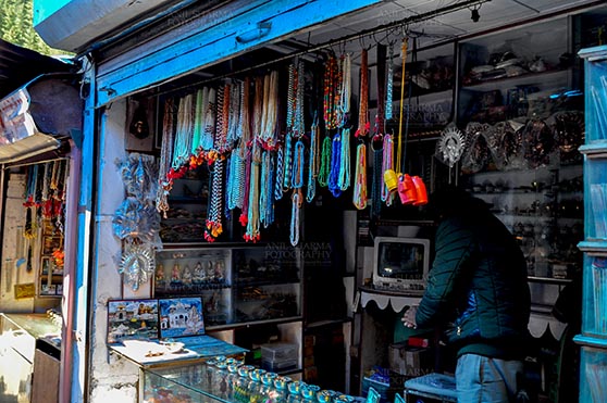 Travel- Gangotri (Uttarakhand) - Gangotri, Uttarakhand, India- May 13, 2015: Shops to buy necklaces, beads, jewelry, gemstones, bracelets, earrings, bangles, and devotional objects for religious ceremonies at Gangotri Bazaar, Uttarkashi, Uttarakhand, India. by Anil