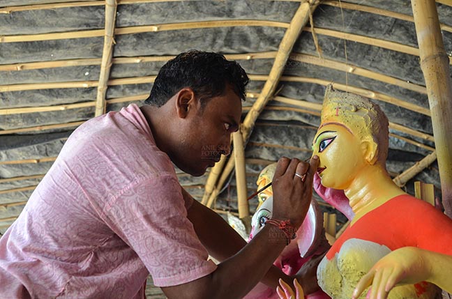 Festivals- Durga Puja Festival - Durga Puja Festival, Noida, Uttar Pradesh, India- September 21, 2017: An artist from West Bengal  giving final touches to the eyes of Goddess Durga’s idol at Noida, Uttar Pradesh, India. by Anil