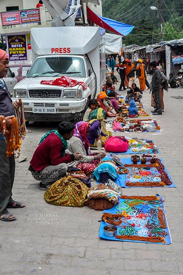 Travel- Gangotri (Uttarakhand) - Gangotri, Uttarakhand, India- June 14, 2013: Local people selling beads, jewelry, gemstones, bracelets, earrings, bangles, on the road side at Gangotri, Uttarkashi, Uttarakhand, India. by Anil