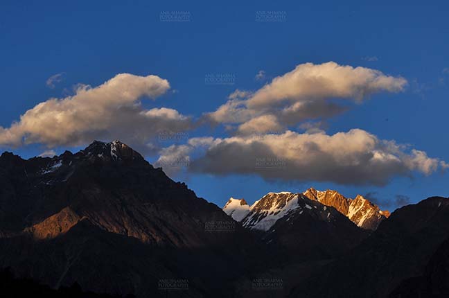 Clouds- Sky with Clouds (Leh) - Clouds over peaks, Leh, Jammu and Kashmir, India- September 25, 2011: Dark blue sky with white clouds floating over the snow covered peaks at Leh, Jammu and Kashmir, India. by Anil