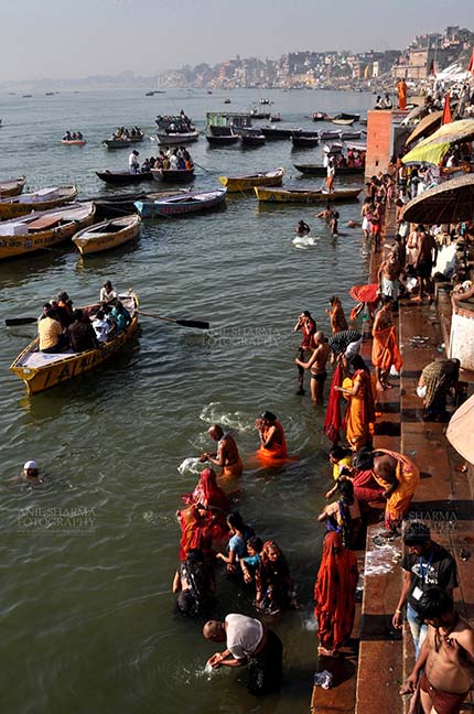 Travel- Varanasi the city of light (India) - Hindu devotees praying in knee deep Ganga water at Ghats at Varanasi, Uttar Pradesh, India. by Anil