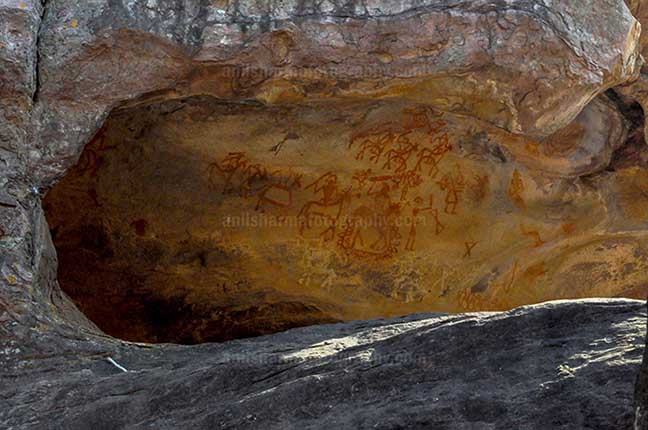 Archaeology- Bhimbetka Rock Shelters (India) - Prehistoric rock painting showing chief of warrior’s leading his team at Bhimbetka archaeological site, Raisen, Madhya Pradesh, India by Anil