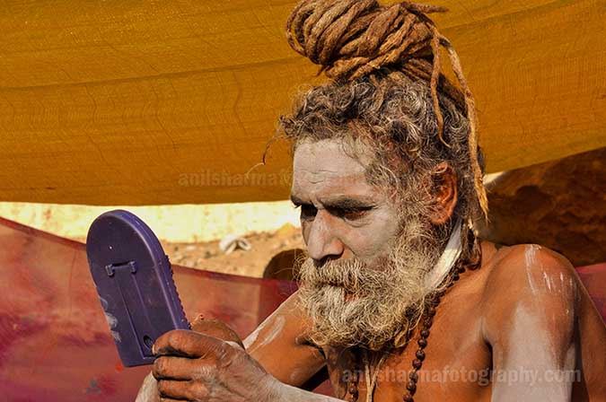Culture- Naga Sadhu\u2019s (India) - A Naga sadhu holding mirror in his hand at Varanasi ghat. by Anil