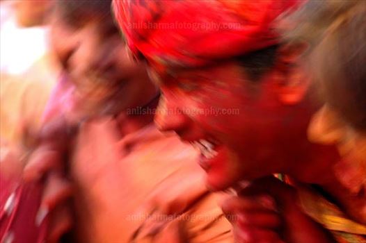 A man daubed in colored powder smiles as he celebrates “Lathmaar Holi”at Mathura, Uttar Pradesh, India.