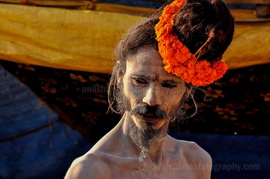 A Naga Sadhu with fancy headdress of marigold flowers at Varanasi Ghats.