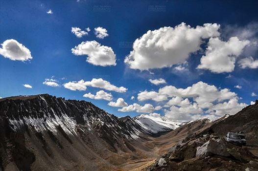 Clouds over Khardung La, India- September 30, 2014 : Dark blue sky with white clouds floating over the snow covered mountain peaks at Khardung La, Leh, Jammu and Kashmir, India.