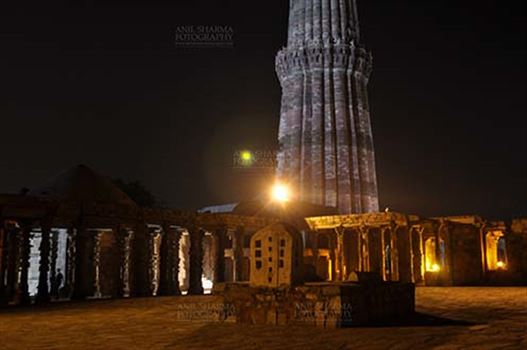 The Beauty of arches of Iltutmish screen and some tourists standing near the iron pillar in night at Qutub Minar Complex, Mehrauli , New Delhi, India.