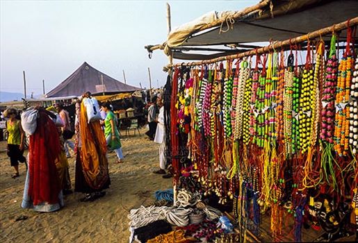 Pushkar, Rajasthan, India- May 23, 2008: Some tourists and a necklaces, beads, jewelry, gemstones, bracelets, earrings, bangles, and devotional object shop for religious ceremonies at Pushkar fair, Rajasthan, India.
