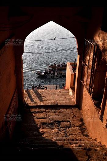 Travel- Varanasi the city of light (India) - View from an old building gates some pilgrims using boats to cross Holy River Ganges to reach their destination at Varanasi, Uttar Pradesh, India.