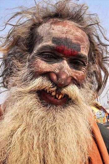 Smile of an old Aghori Sadhu with long hairs, ash on face at Mahakumbh Prayag, Allahabad, Uttar Pradesh (India).